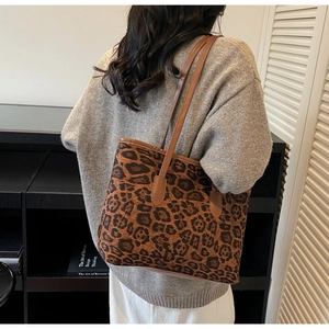 Detailed side view of the large leopard print tote bag with brown leather straps on shoulder