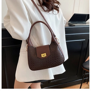 Detail of dark brown woven texture handbag with golden geometric twist lock