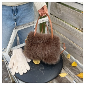 Detailed macro view of soft brown faux fur texture and leather handle on a plush winter handbag