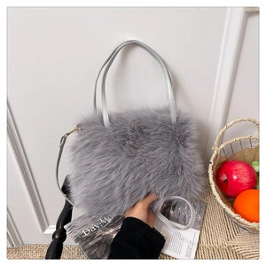Detail of soft grey faux fur texture on a shoulder bag with elegant leather handles