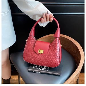 Detail of red woven leather hobo bag featuring premium texture and metal buckle clasp