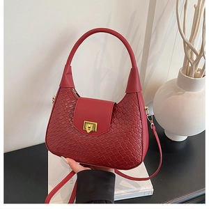 Detail of red woven leather shoulder bag showing intricate texture and golden twist lock