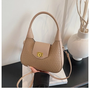 Detailed close-up of woven leather texture and gold twist-lock on a beige hobo bag