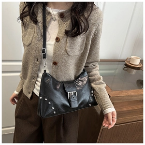 Detail of black vintage tote bag with silver rivets and metal buckle on adjustable strap