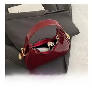 Top view of deep red patent leather mini crescent bag showing internal storage capacity