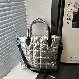 Chic silver quilted puffer tote bag with square stitching and adjustable black strap