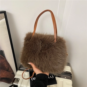 Brown fluffy faux fur handbag with leather handles shown in a minimalist home setting