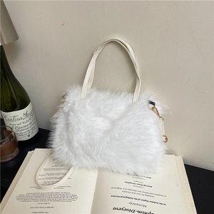 Plush faux fur handbag in white with shoulder strap on a vintage book setting
