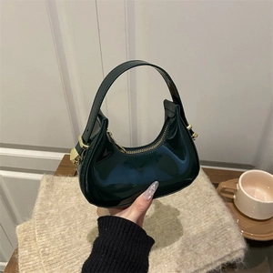 Minimalist dark green crescent handbag in shiny patent leather with golden hardware detail