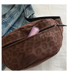 Detail of leopard print crossbody bag showing spacious interior and sleek black zipper