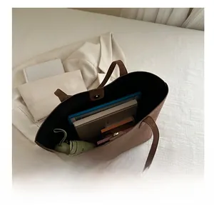 Interior storage display of brown patterned tote bag with tablet and daily essentials