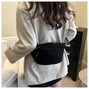 Detail showing black leopard print texture and metal zipper of the stylish crossbody bag