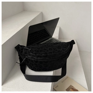 Detail of black leopard print crossbody bag with texture focus and adjustable strap
