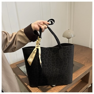 Detail of grey leopard print tote bag with a decorative silk scarf on the handle