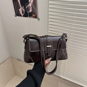Retro brown underarm bag in glossy leather with white stitching and gold buckle