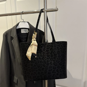 Minimalist dark gray leopard print tote bag with decorative silk scarf hanging on hanger