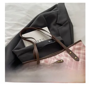 Pink checkered tote bag detail with brown leather straps and white plush bear charm