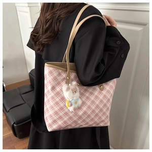 Close-up of pink and white checkered tote bag with a plush bear charm on handles