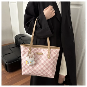 Pink plaid tote bag detail with golden logo plaque and cute white plush bear pendant