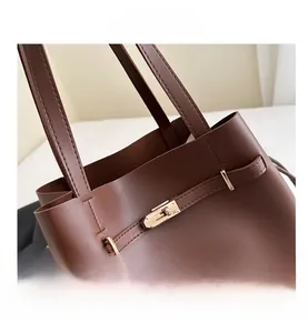 Close-up of the vintage brown leather bucket bag with elegant gold metal buckle detail
