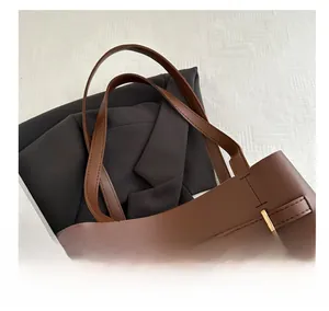 Detailed close-up of brown leather bucket bag with gold hardware and stylish strap