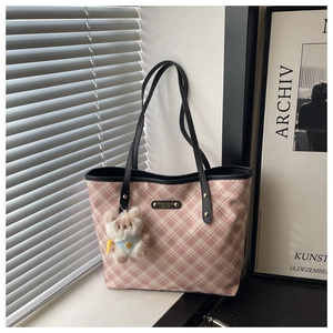 Detail of pink plaid canvas tote with black leather handles and cute bear charm