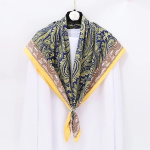 Blue and yellow paisley square silk scarf styled with a gold ring and camellia hanger