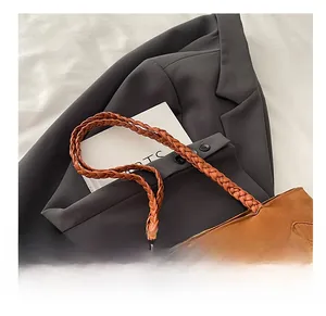 Vue détaillée du sac cabas en daim marron avec poignées tressées et franges