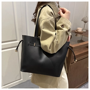 Detail of minimalist black matte leather tote bag with stylish side drawstring accents