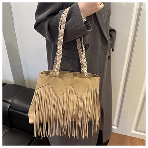 Détail du sac cabas bohème avec poignées tressées et texture de franges en daim