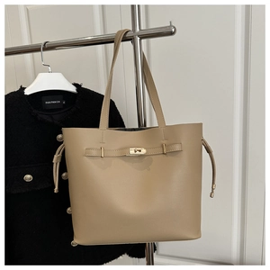 Detail of tan leather bucket bag with gold metal twist lock and side drawstring design