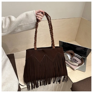 Détail d'un sac cabas marron foncé à franges avec des poignées en corde tressée à la main