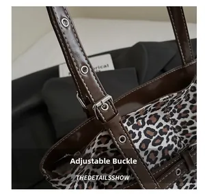 Detail der verstellbaren Silberschnalle und des braunen Lederriemens der Leopard-Tasche