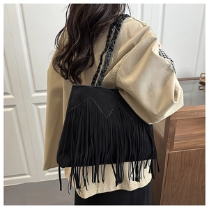 Vue détaillée d'un sac bohème à franges noires avec bandoulière tressée et texture suédée