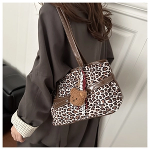 Detailaufnahme der Shopper-Tasche mit Leopardenmuster, Lederriemen und Bärenanhänger