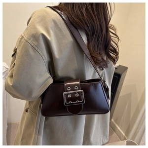 Detail shot of vintage dark brown faux leather shoulder bag with decorative metal buckle