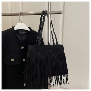 Détail du sac cabas à franges noires avec coutures zigzag et poignée tressée