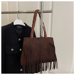 Détail du sac cabas marron foncé à franges avec anses en cuir tressées style bohème