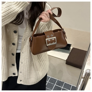 Detail of vintage brown leather underarm bag with large silver metal square buckle