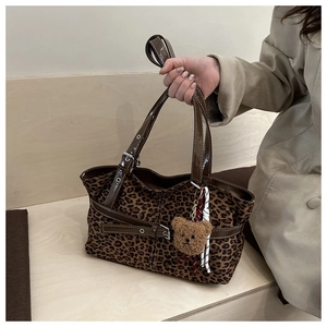 Detailaufnahme der Leoparden-Wildledertasche mit Lederriemen und Plüschbär-Anhänger