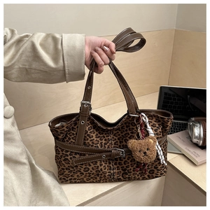 Detail der Leoparden-Wildleder-Tote Bag mit Lederriemen und süßem Plüschbär-Anhänger