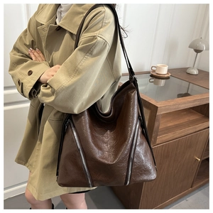 Dettaglio della borsa tote vintage in pelle cerata marrone scuro con cerniere argentate