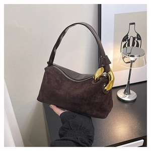 Close-up of matte suede Boston bag featuring a prominent gold metal buckle on shoulder strap
