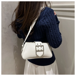 Detailed view of cream leather shoulder bag with large silver buckle and twin eyelets