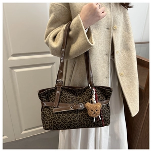 Detail der Wildleder-Tote-Bag mit Leopardenmuster, braunem Lederbesatz und Bärenanhänger