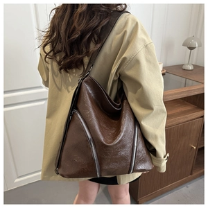 Dettaglio borsa tote vintage in pelle cerata marrone scuro con cerniere sul modello