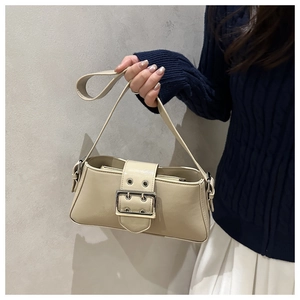 Detail showing the retro beige shoulder bag with stylish silver metal buckle strap