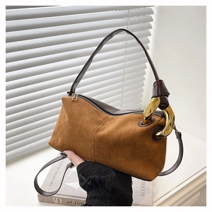 Detailed view of brown suede Boston bag featuring unique gold metal buckle and zipper