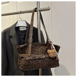 Detail der Wildleder-Einkaufstasche mit Leopardenmuster, Lederriemen und Bär-Anhänger