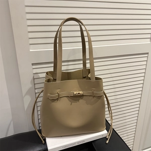 Minimalist khaki leather bucket tote bag with decorative metal lock and drawstring detail